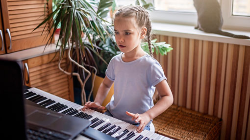 Child learning to play paino online.